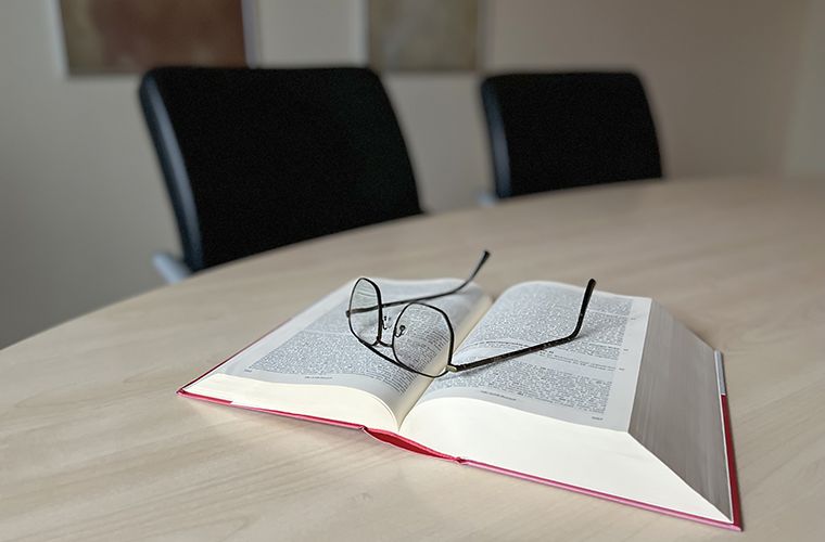 Sonnenbrille auf geöffnetem Buch